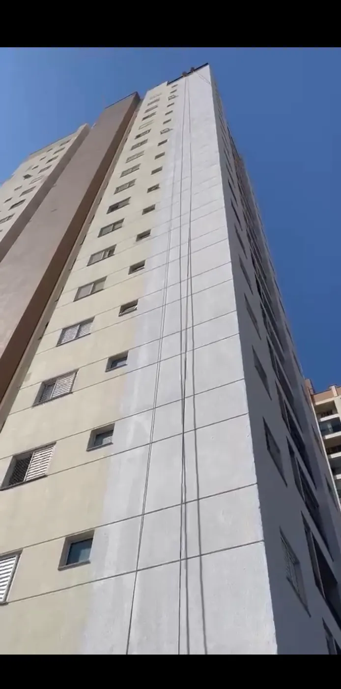 Pintura de fachada em prédio alto com cordas de alpinismo industrial